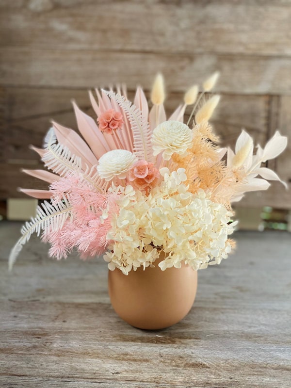 Dried flower arrangement, white and pink colours, in a clay coloured pot