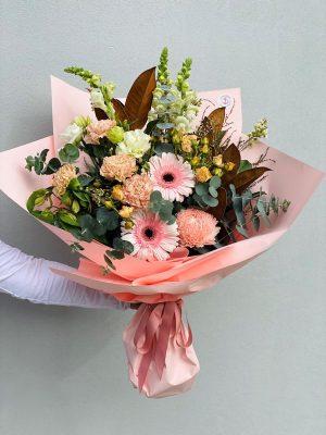 Bouquet of flowers in pink wrapping and pink ribbon