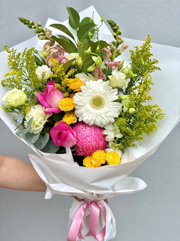 Bouquet of flowers in white wrapping and pink ribbon